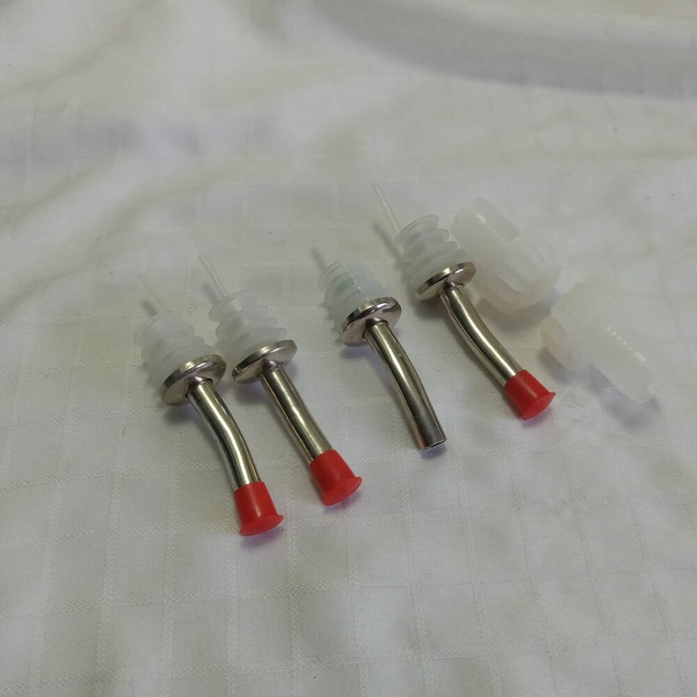 Four metal spouts (miss one cap) and two clear plastic caps